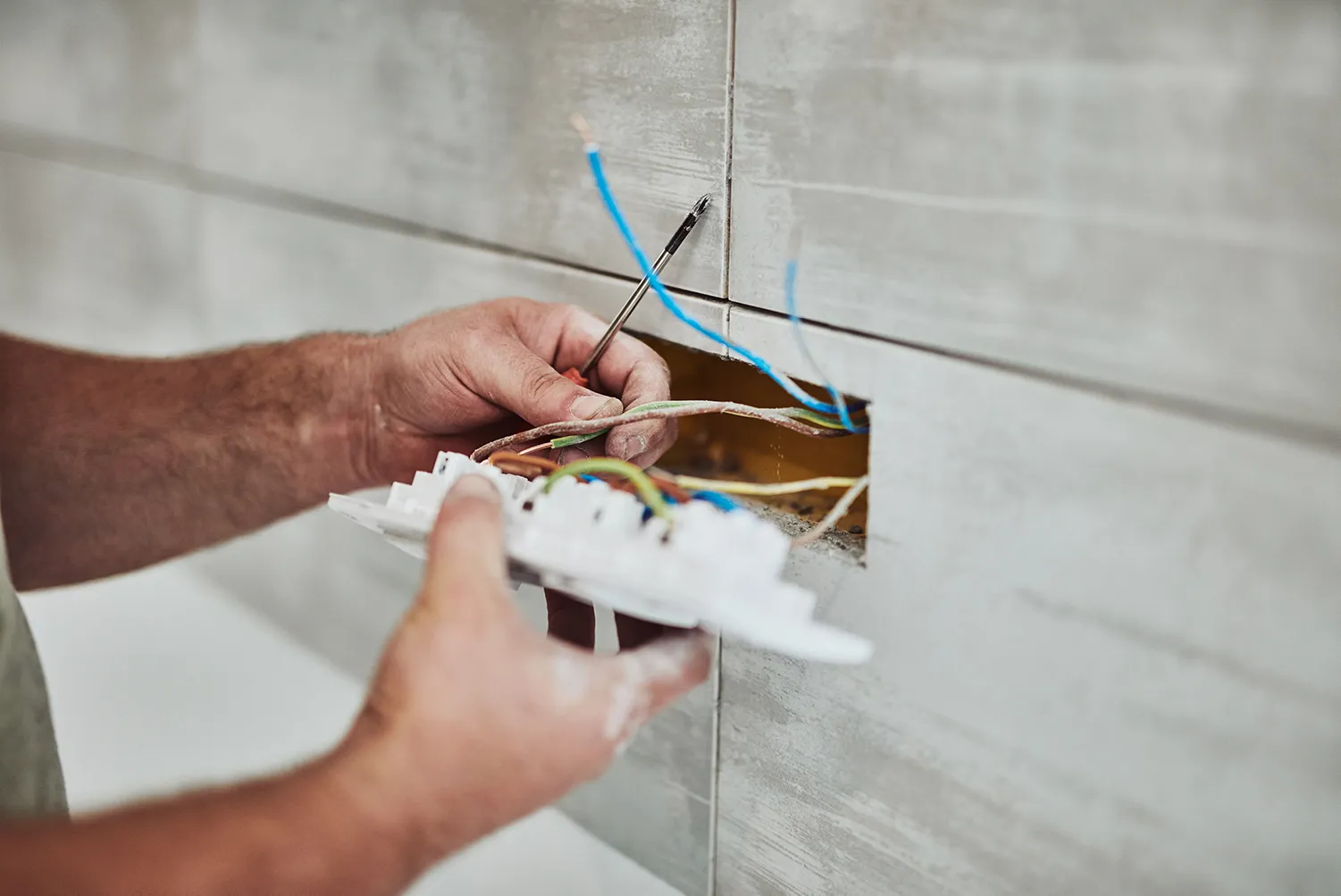 Elektriker repariert/repariert Kabel in der Wand.